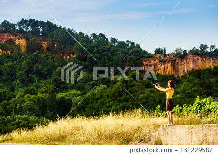 Woman take photo from red rocks in Roussillon, Provence France Woman take photo from red rocks in Roussillon, Provence France 131229582