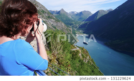 Tourist taking photo of fjord landscape, Norway Tourist taking photo of fjord landscape, Norway 131229624
