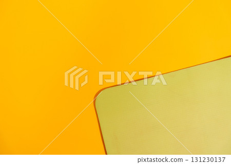 Minimal yellow background with corner of green fitness mat textured copy space workout backdrop 131230137