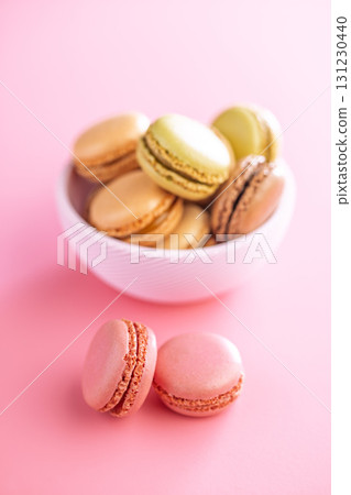 Different flavors of macarons. Colourful macaroons on pink background. 131230440