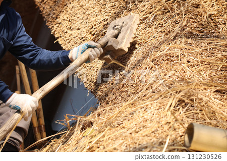 A craftsman aligning the thatched roof 131230526