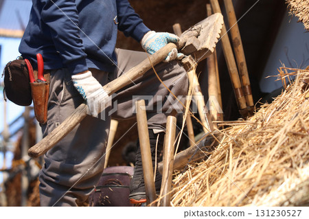 A craftsman aligning the thatched roof A craftsman aligning the thatched roof 131230527