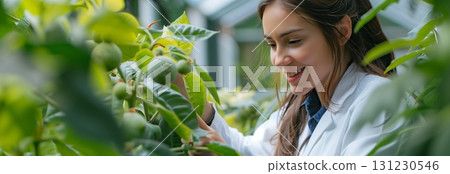 A woman in a greenhouse examines plants, showcasing a passion for gardening and horticulture. 131230546