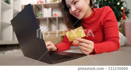Festive Online Shopping. Woman with credit card using laptop for Christmas gifts. Festive Online Shopping. Woman with credit card using laptop for Christmas gifts. 131230800