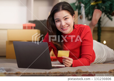 Christmas Online Shopping. Happy woman lying on the floor with credit card and laptop. Christmas Online Shopping. Happy woman lying on the floor with credit card and laptop. 131230806