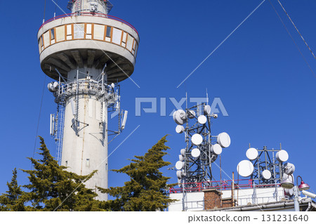 Telecommunication tower and water tank rising into blue sky 131231640