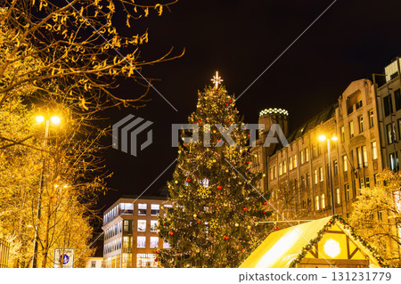 Illuminated Christmas tree with festive decorations in city square 131231779