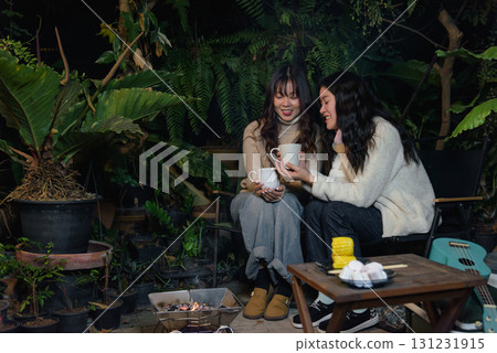 Happy woman friend people enjoy winter outdoor camp activities, forest night, warm drink barbecue create cozy winter evening atmosphere. Happy woman friend people enjoy winter outdoor camp activities, forest night, warm drink barbecue create cozy winter evening atmosphere. 131231915