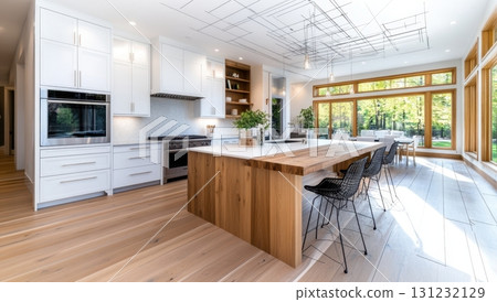 Bright kitchen interior with white cabinets, wood island, and large windows showcasing the nature views. Modern design with creative ceiling art. Cozy dining table set in the background 131232129