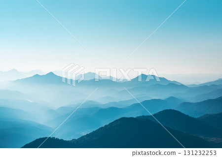 Dreamy landscape of layered mountain silhouettes in various shades of blue under a clear sky Dreamy landscape of layered mountain silhouettes in various shades of blue under a clear sky 131232253
