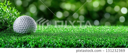 A golf ball rests on lush green grass, ready for a perfect shot on a sunny day 131232369