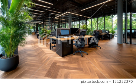 Modern office interior with wooden flooring, stylish workstations, and abundant greenery 131232370