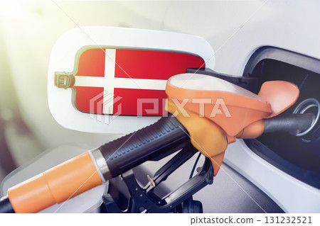 The Danish flag on the lid of the gas tank of a car at a gas station in close-up. High or low prices at Danish gas stations. Problems with the quality of gasoline and diesel fuel and their shortage in The Danish flag on the lid of the gas tank of a car at a gas station in close-up. High or low prices at Danish gas stations. Problems with the quality of gasoline and diesel fuel and their shortage in 131232521
