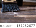 Close-up of a broom sweeping dust and dirt on a wooden floor 131232677