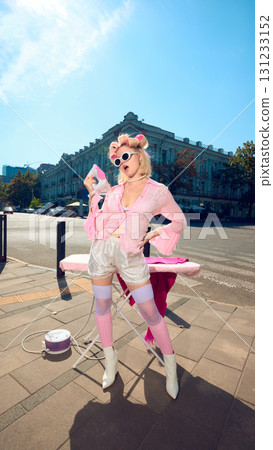 Playful stylish woman with pink curlers and retro outfit posing with iron outdoors Playful stylish woman with pink curlers and retro outfit posing with iron outdoors 131233152