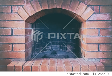 red brick fireplace with open hearth close-up, traditional heating method 131233505