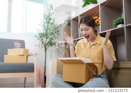 Online Shopping. Woman expressing joy while unboxing a delivery. Online Shopping. Woman expressing joy while unboxing a delivery. 131233575