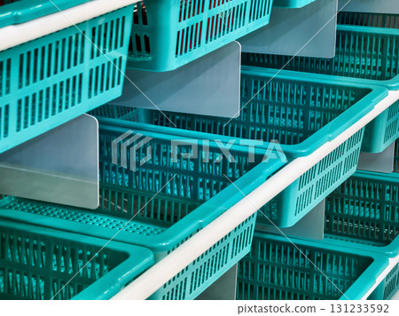 Shopping baskets neatly arranged in a store aisle, ready for customers to use during their shopping trip 131233592