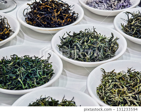 Various types of loose leaf tea displayed in white bowls at a tea shop during a sunny afternoon Various types of loose leaf tea displayed in white bowls at a tea shop during a sunny afternoon 131233594