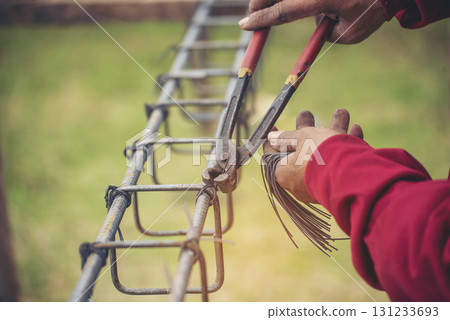Construction Worker hands using pincer pliers iron wire. Outdoor Worker using wire bending pliers, construction work. Men hands bending cutting steel wire fences bar reinforcement of concrete work 131233693