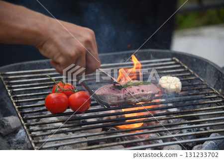 BBQ Barbecue grilled meat stick on fire flame with hot charcoal cooking outside. Beef grilling picnic outdoor with smoke bacon spicy sausage for party. Grill pork bbq on fire flame 131233702