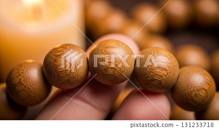 Hand holding wooden prayer beads with warm lighting and shallow depth of field 131233718