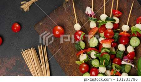 Italian appetizer with cherry tomatoes, cucumbers and mozzarella on a wooden board Italian appetizer with cherry tomatoes, cucumbers and mozzarella on a wooden board 131233786