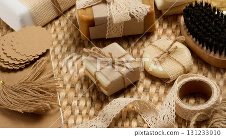 Handmade soap bars on marble stand and packaging items on table 131233910