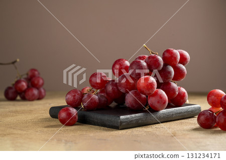 Pink grapes on brown neutral background, autumn harvest concept. Pink grapes on brown neutral background, autumn harvest concept. 131234171