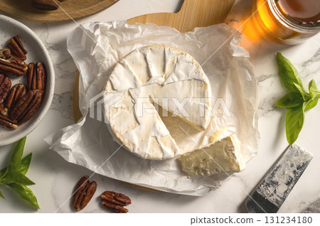 Camembert soft round cheese, served with honey, nuts and dried fruits. Cheese board Camembert soft round cheese, served with honey, nuts and dried fruits. Cheese board 131234180