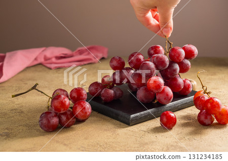 Pink grapes on brown neutral background, autumn harvest concept. 131234185