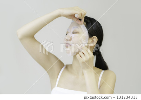 Young woman applying sheet mask 131234315