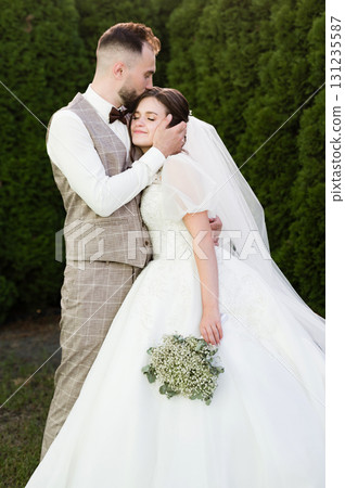 Tender moment: Groom kisses bride's forehead. Romantic wedding day portrait. Tender moment: Groom kisses bride's forehead. Romantic wedding day portrait. 131235587