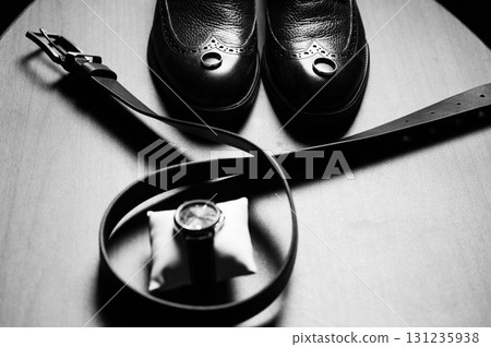 Groom's getting ready essentials: black shoes, belt, and watch. Groom's getting ready essentials: black shoes, belt, and watch. 131235938