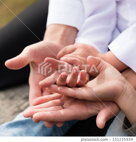 Family hands clasped together, symbolizing love, unity, and connection. Family hands clasped together, symbolizing love, unity, and connection. 131235939