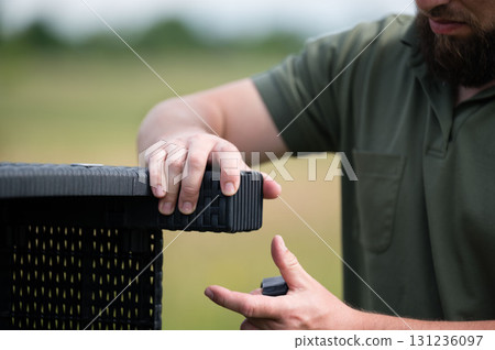 Man assembling outdoor patio furniture. Easy setup, enjoying the summer. 131236097