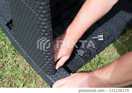 Assembling outdoor wicker furniture on grass. Easy-to-follow instructions. Assembling outdoor wicker furniture on grass. Easy-to-follow instructions. 131236170