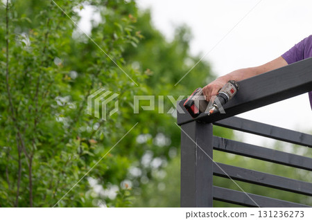 The craftsman screws into the wooden beam to connect the wall to the upper beam. The craftsman screws into the wooden beam to connect the wall to the upper beam. 131236273