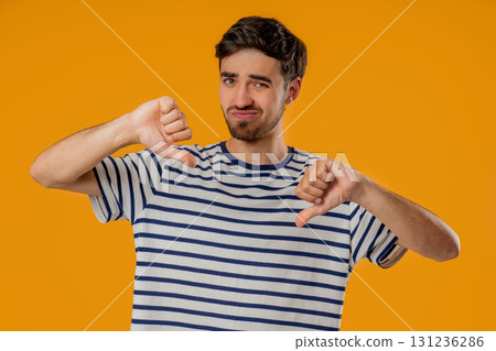 Portrait of unhappy man condemns with sign of dislike. Young millennial guy 131236286