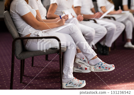 Close up of a student holding a pen and writing notes in a notebook during a professional training and education session in a wellness and therapy course Close up of a student holding a pen and writing notes in a notebook during a professional training and education session in a wellness and therapy course 131236542