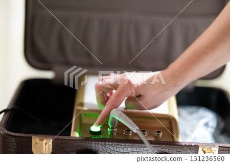 Close up of a therapists hand adjusting the settings on an electrotherapy machine before physiotherapy treatment. Concept of modern rehabilitation, medical technology, and therapeutic healthcare 131236560