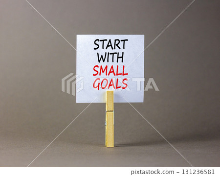 Start with small goals symbol. Concept words phrase Start with small goals on beautiful white paper on clothespin. Beautiful grey background. Business Start with small goals concept. Copy space. 131236581