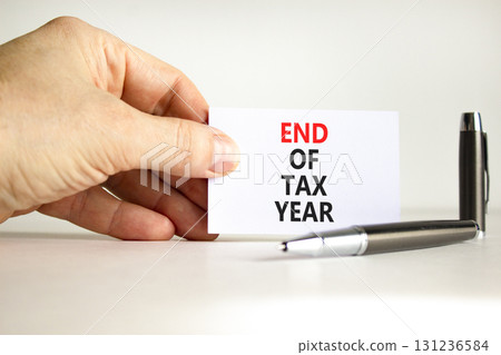 End of tax year symbol. Concept words phrase End of tax year on beautiful white card. Businessman's hand. Beautiful white paper background. Business End of tax year concept. Copy space. 131236584