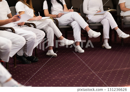 Close up of a student holding a pen and writing notes in a notebook during a professional training and education session in a wellness and therapy course 131236626