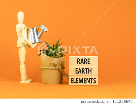 Rare earth elements symbol. Concept words Rare earth elements on beautiful wooden block. Businessman model. Beautiful orange background. Business and rare earth elements concept. Copy space. Rare earth elements symbol. Concept words Rare earth elements on beautiful wooden block. Businessman model. Beautiful orange background. Business and rare earth elements concept. Copy space. 131236643