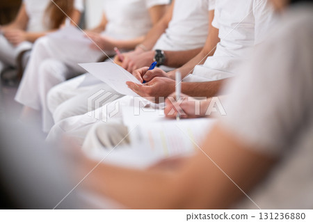 Close up of a student holding a pen and writing notes in a notebook during a professional training and education session in a wellness and therapy course Close up of a student holding a pen and writing notes in a notebook during a professional training and education session in a wellness and therapy course 131236880