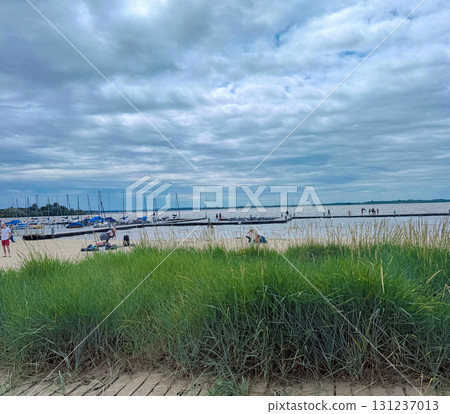 Sandy beach with grass and a view of the lake. A place for walking or relaxing with the whole family Sandy beach with grass and a view of the lake. A place for walking or relaxing with the whole family 131237013