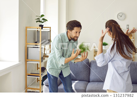 Angry young couple arguing at home, facing relationship problems, husband shouting at stressed wife. 131237982