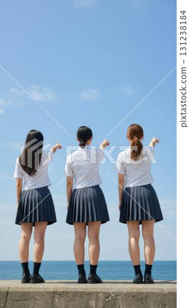 Back view of three high school girls pointing towards the sea and looking to the future Back view of three high school girls pointing towards the sea and looking to the future 131238184