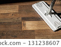 Close-up of a mop cleaning a wooden floor with water and detergent 131238607